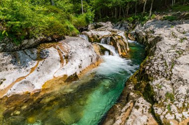 Slovenya 'daki engebeli kireçtaşı kayaların üzerinden zarif bir şelale akıyor. Triglav Ulusal Parkı sükunet ve doğal güzelliği çağrıştırıyor.