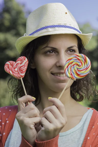 Cute hipster girl holding lollipops — Stock Photo, Image
