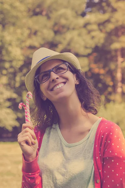 Szczęśliwy hipster dziewczynka gospodarstwa cukierków laski — Zdjęcie stockowe
