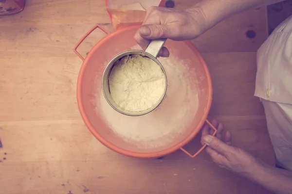 Sifting flour for kneading. Retro colors — Stock Photo, Image