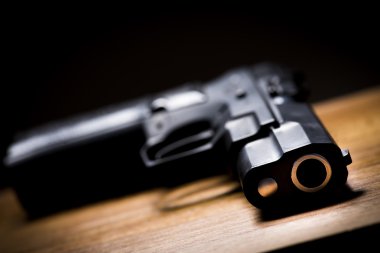 Handgun on a wooden background. clipart