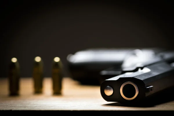 Pistola negra y balas sobre fondo de madera . —  Fotos de Stock