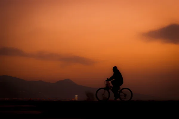 Jedoucí na kole na soumraku — Stock fotografie