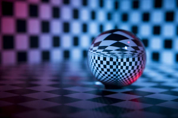 Glass ball on a checkered background — Stock Photo, Image