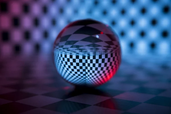 Glass ball on a checkered background — Stock Photo, Image