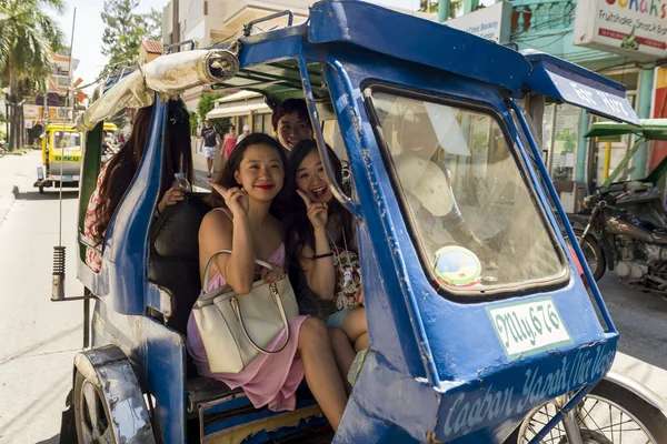 Kinesiska turister på en motordriven trehjuling. — Stockfoto