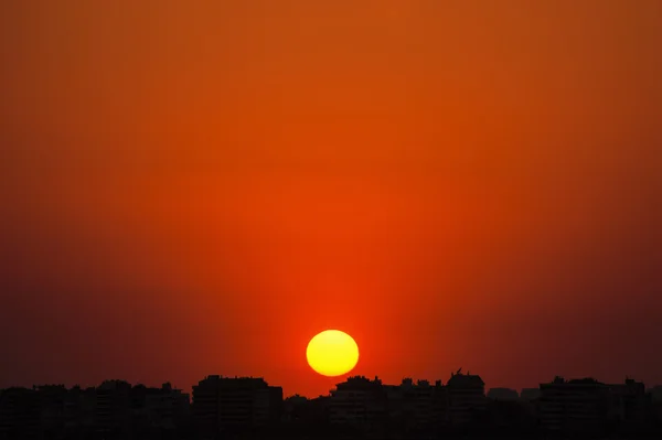 Solnedgången bakom byggnaderna — Stockfoto