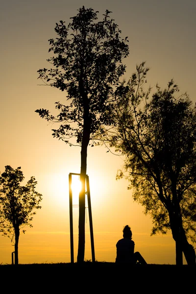 Frau sitzt auf Sonnenuntergang. — Stockfoto