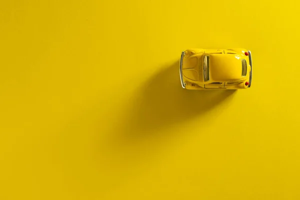 Вид Сверху Желтый Игрушечный Автомобиль Желтом Фоне Длинной Боковой Тенью — стоковое фото