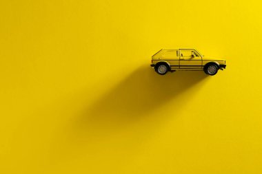 İzmir, Türkiye - 29 Eylül 2020: Sarı arka planda uzun ve yan gölgeli sarı bir Volkswagen Golf arabasının sağdan görünüşü.