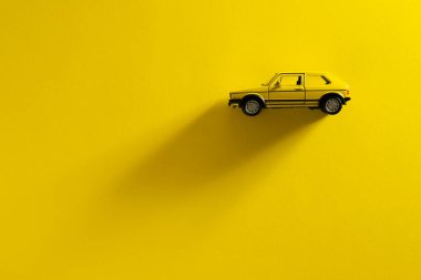 İzmir, Türkiye - 29 Eylül 2020: Sarı arka planda uzun ve yan gölgeli sarı bir Volkswagen Golf arabasının sol tarafı.