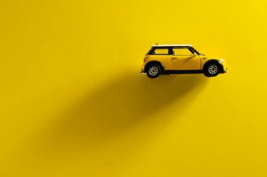 İzmir, Türkiye - 30 Eylül 2020: Sarı arka planda uzun gölgeli Mini Cooper S Sarı oyuncak araba