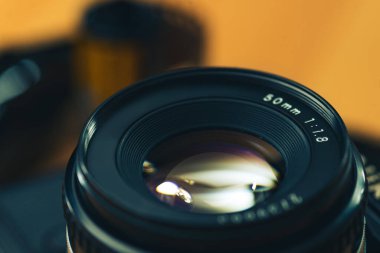 Tahta arka planda 35 mm 'lik negatif bir film olan analog bir kameranın canlı görüntüsü.