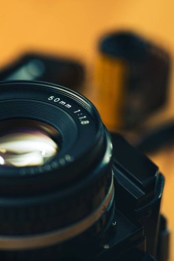 Tahta arka planda 35 mm 'lik negatif bir film olan analog bir kameranın canlı görüntüsü.