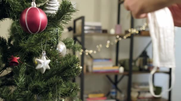 Κρεμώντας Μια Λευκή Μάσκα Προσώπου Ένα Χριστουγεννιάτικο Δέντρο Στολίδι — Αρχείο Βίντεο