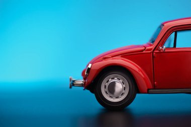 Close up shot of a Partial front view red colored toy model car on a blue background. clipart