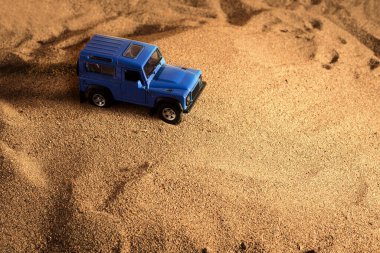 İzmir, Türkiye - 20 Nisan 2021: Kum zemininde mavi renkli 4x4 SUV model bir aracın üst görünümü.