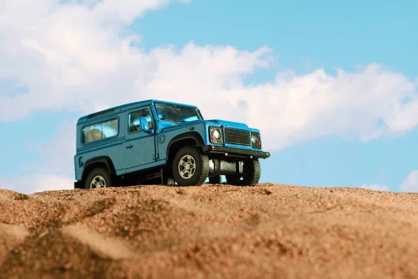 İzmir, Türkiye - 20 Nisan 2021: Kum ve mavi zemin üzerinde mavi renkli 4x4 SUV Car 'ın yakın çekimi.