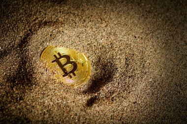 Bitcoin 'i kısmen kuma gömmüş ve ışık saçmış..