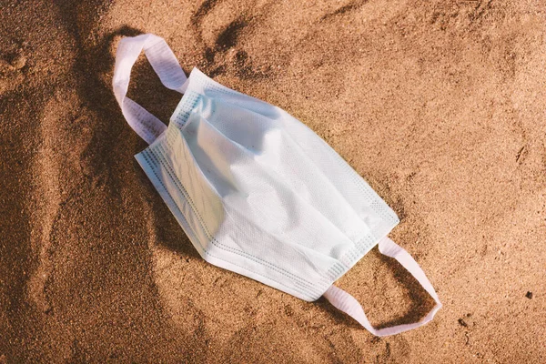 Medizinische Maske Auf Sand Und Blauem Himmel Geworfen — Stockfoto