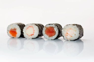 Beyaz arka planda dört suşi Ebi Maki, Kani Maki Sake Maki Maguro maki.