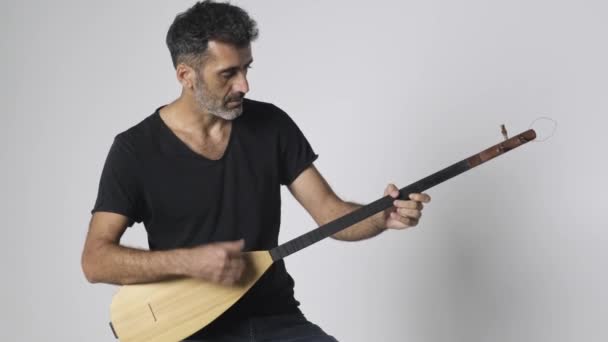 中东人演奏Kopuz 这是一种弦乐器 名字叫做Baglama 有三根弦 背景是白色的 — 图库视频影像