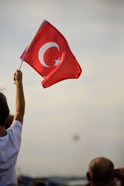 İzmir, Türkiye - 9 Eylül 2021: Türk bayrağı ve polis helikopterleri taşıyan bir çocuk İzmir 'in özgürlük gününde gökyüzünde gösteri yapıyor.