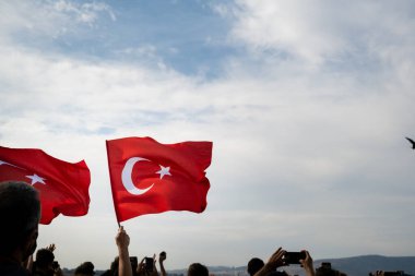 İzmir, Türkiye - 9 Eylül 2021: İzmir 'in Özgürlük Günü, insanların ellerinde Türk bayrakları var. Gundogdu Meydanı
