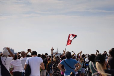 İzmir, Türkiye - 9 Eylül 2021: İzmir 'in özgürlük gününde üzerinde Atatürk Portresi bulunan Türk bayrağı sallayan insanlar