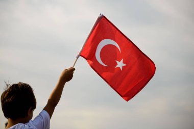 İzmir, Türkiye - 9 Eylül 2021: İzmir 'in özgürlük gününde elinde Türk bayrağı sallayan bir çocuk.