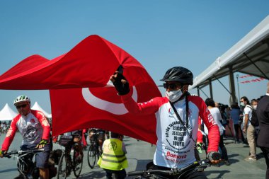 İzmir, Türkiye - 9 Eylül 2021: İzmir Belediye Başkanı Tunc Soyer 'e hediye olarak büyük bir Türk bayrağı taşıyan Bisiklet Sürücüsü grubu