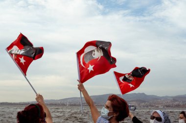 İzmir, Türkiye - 9 Eylül 2021: İzmir 'in özgürlük gününde Atatürk' ün kendilerine çektiği Türk bayraklarını sallayan kalabalık