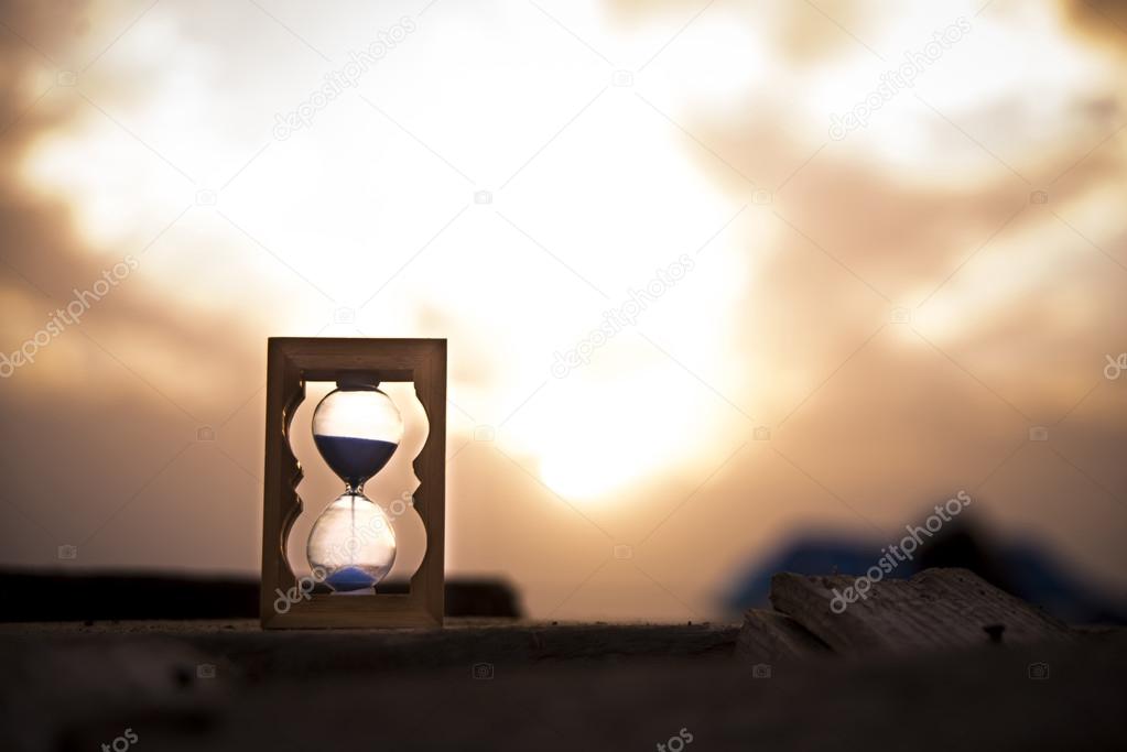 Hourglass on wooden pier.