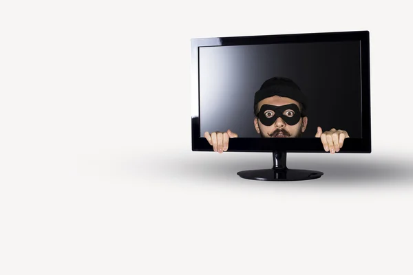Schockierter Einbrecher in einem Computermonitor auf weißem Hintergrund. — Stockbild Einbrecher — Stockfoto