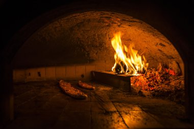 Cooking pide in a stone oven clipart