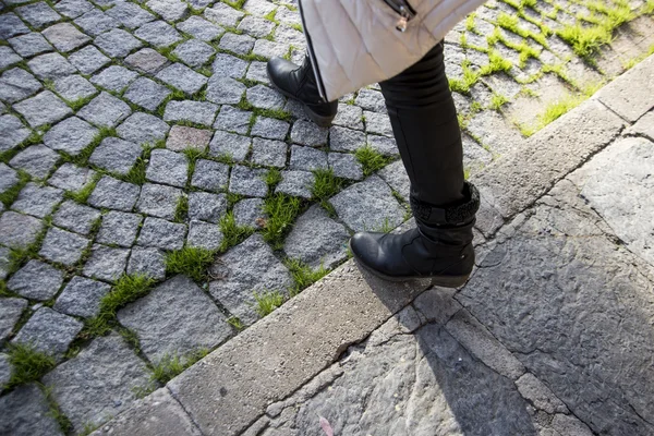 Woman walking on a street which made with cobblestone. — Stock Photo, Image