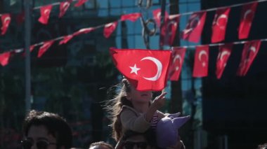 İzmir, Türkiye - 29 Ekim 2025: Kızın babasının omuzlarında Cumhuriyet Günü kutlamalarında Türk bayrağını coşkuyla salladığı yavaş çekim videosu.