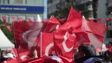 İzmir, Türkiye - 29 Ekim 2025: Cumhuriyet Günü kutlamaları sırasında Türk bayraklarını sallayan coşkulu kalabalığın yavaş çekim videosu.