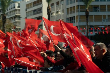 İzmir, Türkiye - 29 Ekim 2025: İzmir halkı, Alsancak Meydanı 'ndaki Cumhuriyet Günü kutlamaları sırasında gösterileri izlerken coşkuyla bayrak sallıyor