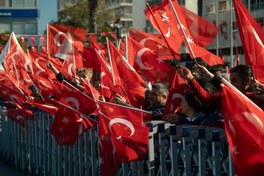 İzmir, Türkiye - 29 Ekim 2025: İzmir halkı, Alsancak Meydanı 'ndaki Cumhuriyet Günü kutlamaları sırasında gösterileri izlerken coşkuyla bayrak sallıyor