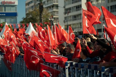 İzmir, Türkiye - 29 Ekim 2025: İzmir halkı, Alsancak Meydanı 'ndaki Cumhuriyet Günü kutlamaları sırasında gösterileri izlerken coşkuyla bayrak sallıyor
