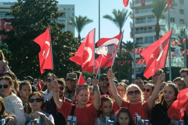 İzmir, Türkiye - 29 Ekim 2025: İzmir halkı, Alsancak Meydanı 'ndaki Cumhuriyet Günü kutlamaları sırasında gösterileri izlerken coşkuyla bayrak sallıyor