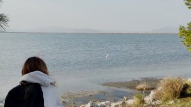 İzmir 'deki kadın Sasal Cennet' te yürüyor, sudaki kuşların amatör fotoğraflarını çekiyor.