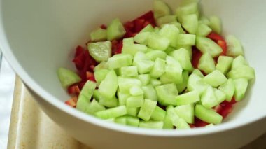 Doğranmış domateslerin karton kaplara biber ve salatalıkla doldurulduğu yavaş çekim videoları.