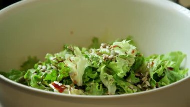 Ekstra doku ve beslenme için taze salataya serpilmiş tohumların yavaş çekim videosu.