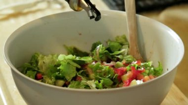  Zeytinyağının sağlıklı soslar için taze salataya serpildiği yavaş çekim videosu.