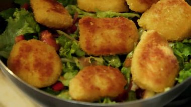 Gevrek nuggetların yavaş çekim videosu eklenen protein için taze salatanın üzerine yerleştiriliyor.
