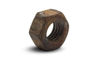 Şeffaf arka planda izole edilmiş paslı ve yaşlanmış bir fındığın makro yakın plan fotoğrafı ayrıntılı aşınma, kaba doku ve otantik endüstriyel bozulmayı vurguluyor..