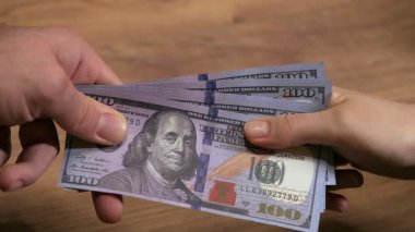 100 dolarlık banknotları çekiştirip çeken iki elin yavaş çekimini kapat, ikisi de bırakmak istemiyor..