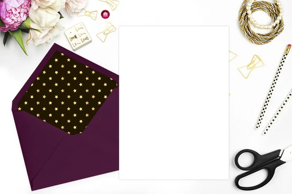 Flat lay, wedding invitation blank. Woman modern scene, feminine background. Table view up.Glamour style.The workspace on the desk, envelope, scissors, Bracelet with flowers